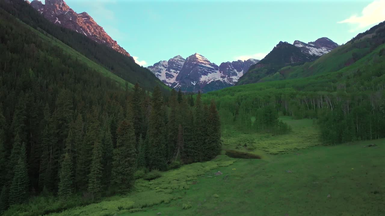 Maroon Bells North Maroon Wilderness valley aerial drone Colorado Elk Range Rocky Mountains spring summer golden sunset blue sky clouds Aspen Snowmass White River National Forest circle right motion