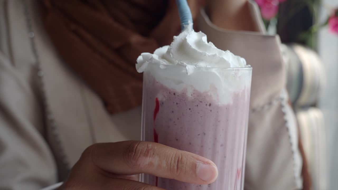 una mujer disfrutando de un batido de bayas.