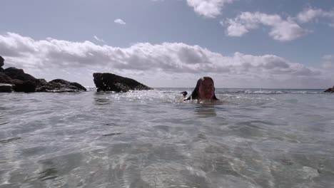 Kaukasische-Frau,-Die-Auf-Einem-Flachen-Natürlichen-Wasserbecken-Schwimmt