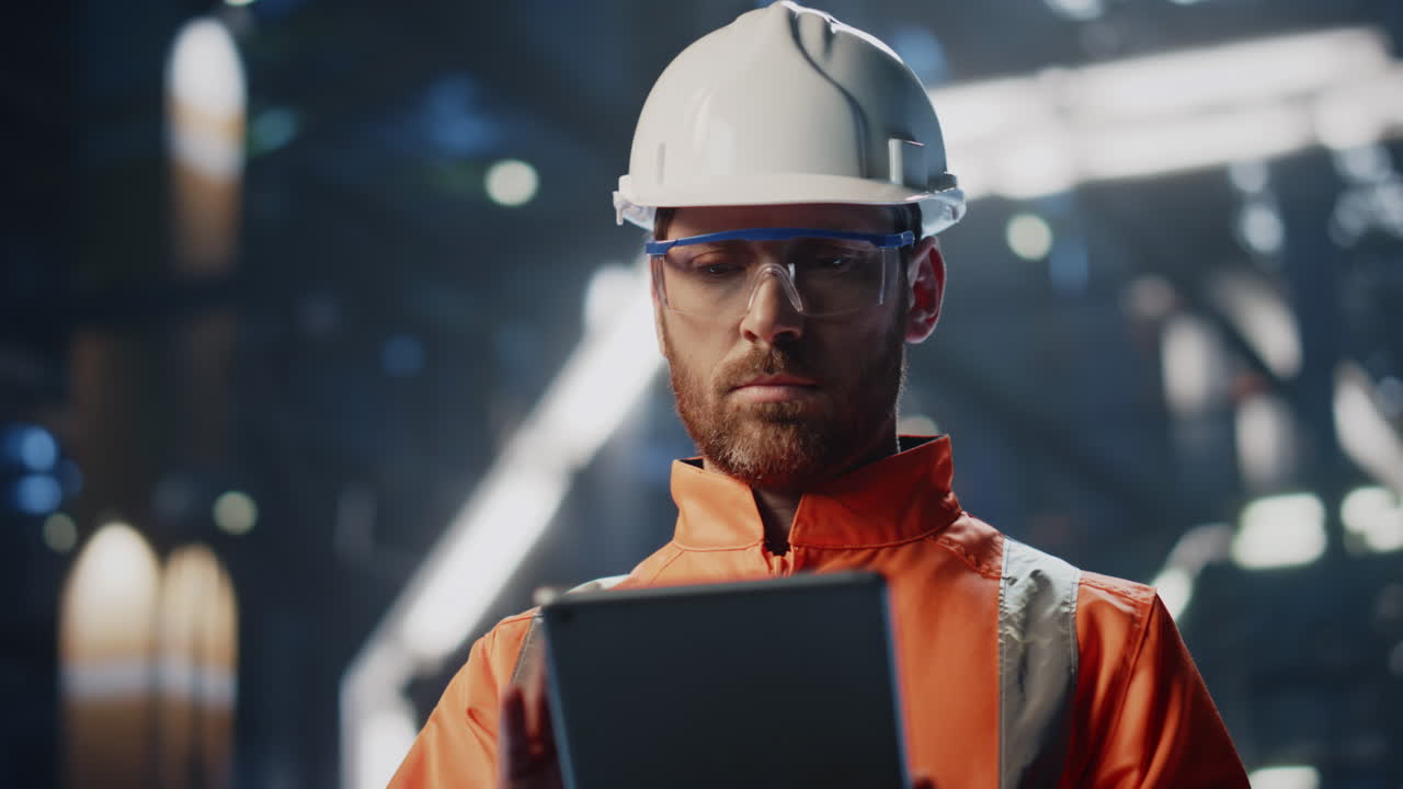 Skilled technician inspecting production industrial facility with tablet closeup