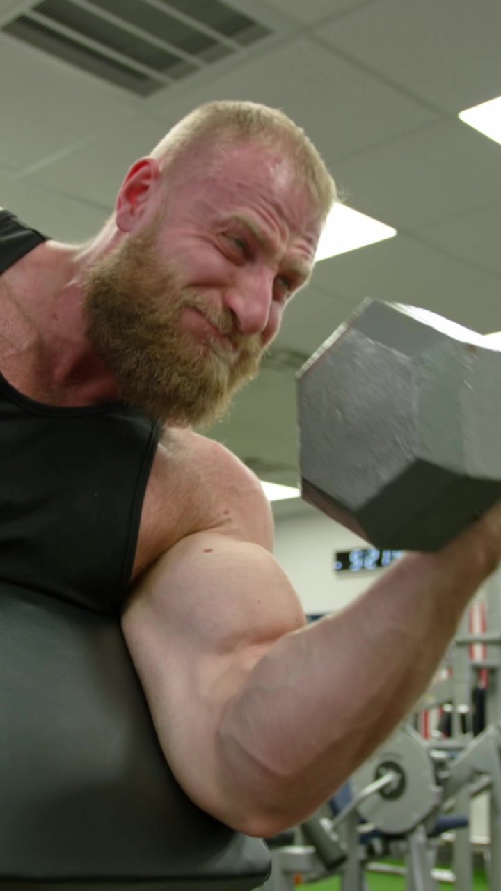 Bodybuilder muscoloso che solleva pesi. Persona atletica che si impegna
