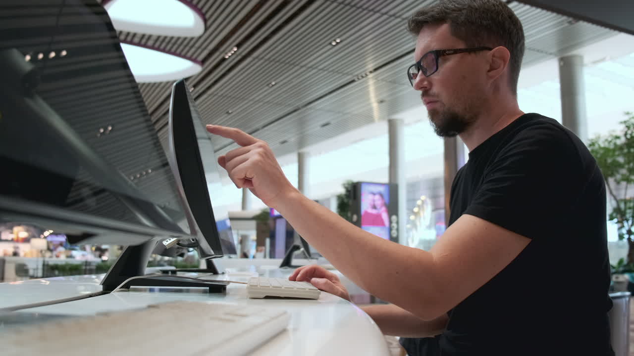 Man using computer at airport kiosk
