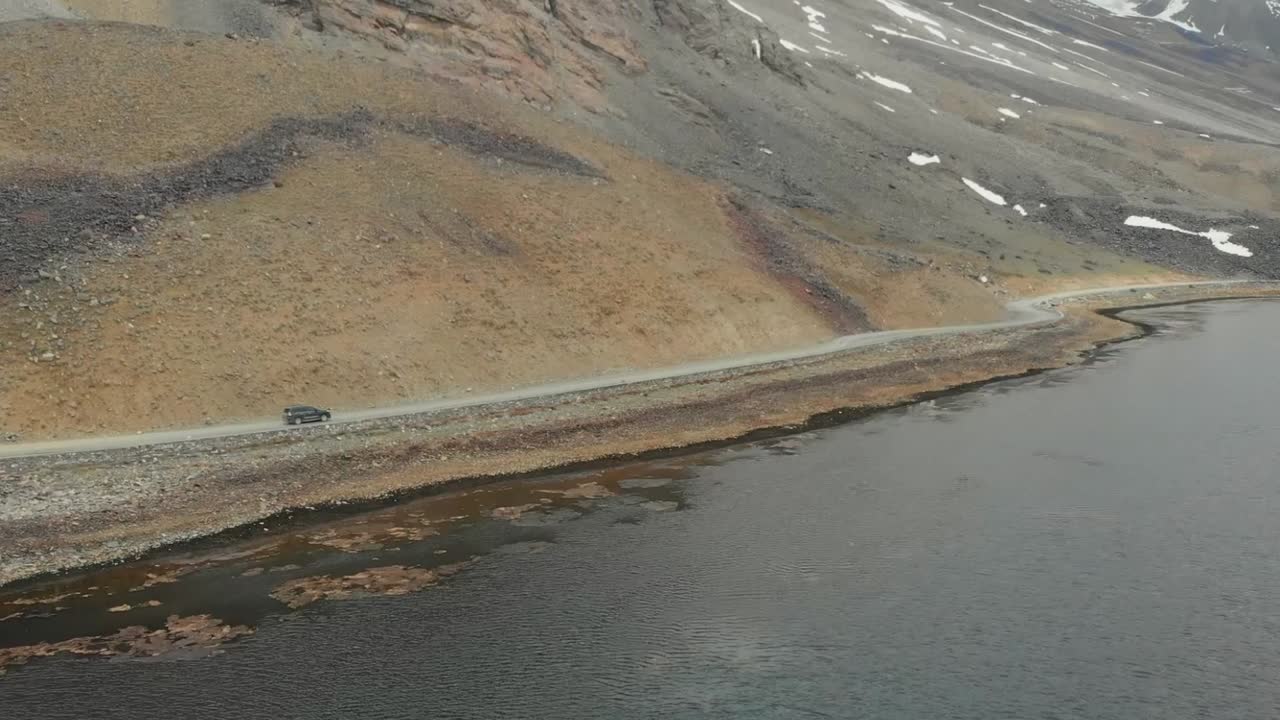 Aerial View Of SUV Going Along Road Beside Shandur Lake In Pakistan. Slow Motion Dolly Forward