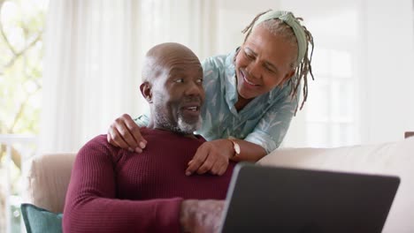 Happy-african-american-senior-couple-using-laptop-at-home,-slow-motion