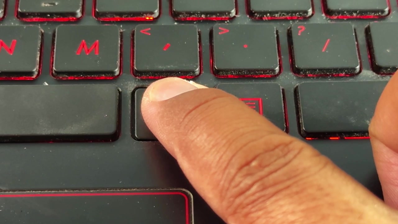 Skriver på baggrundsbelyst "alt"-knap på bærbar tastatur i makrovisning, ideelt til programmering, cybersikkerhed og temaer inden for digitale miljøer.
