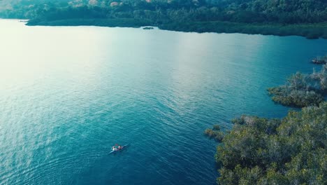 Couple-Kayaking-Next-to-Mangrove-to-a-Skyline-of-Mountains