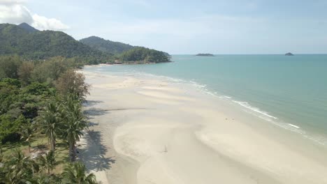 Aerial-descending-footage-of-tropical-white-sand-beach-with-coco-palms,-ocean-and-jungle