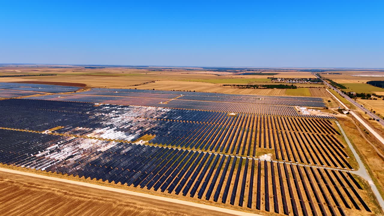 Numerous rows of solar panels in the countryside. Vast fields used for renewable energy production. Aerial view