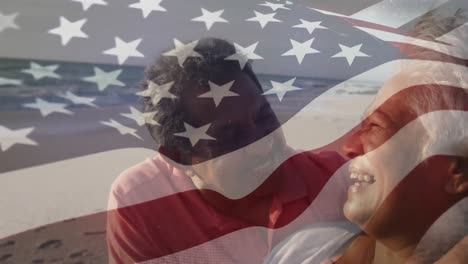 Animation-of-flag-of-united-states-of-america-over-senior-biracial-couple-on-beach