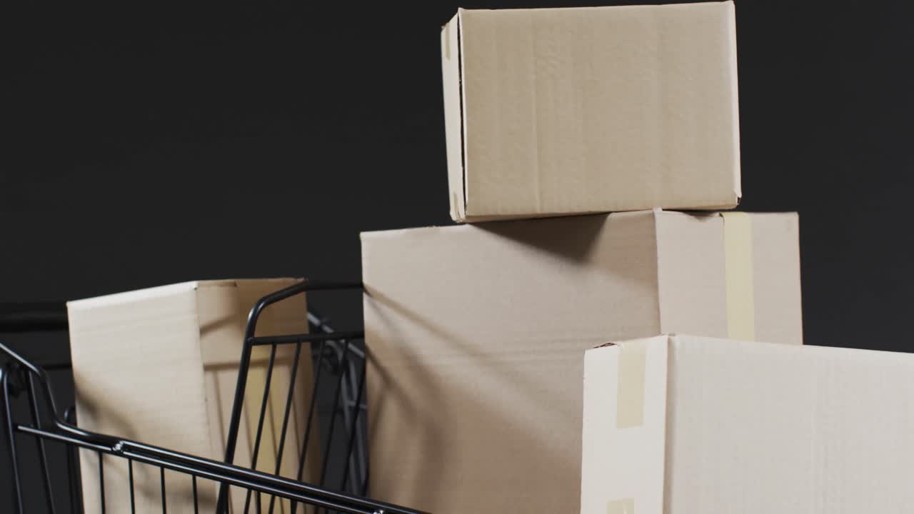 Video of shopping trolley and boxes with copy space over grey background