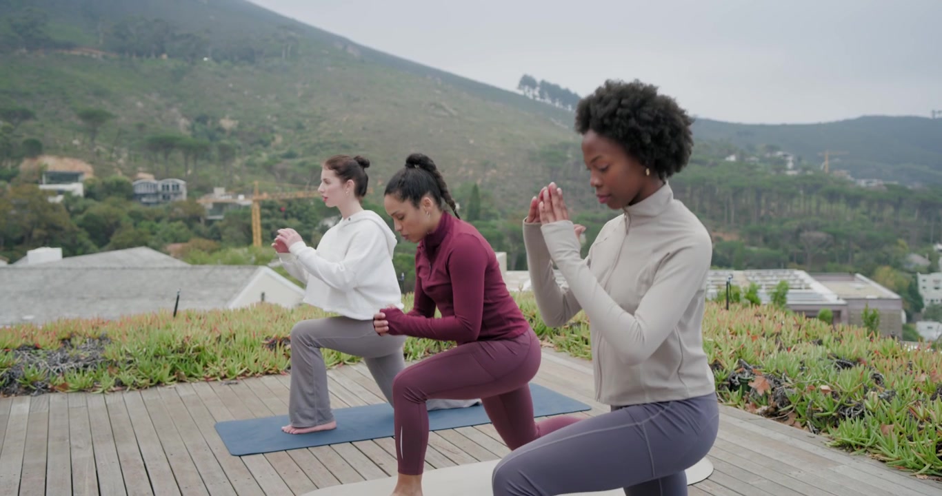 Tre donne che seguono l'istruttrice, eseguendo affondi a passo e pulsanti, piegandosi su tappetini da yoga su un tetto, spazio per il testo.