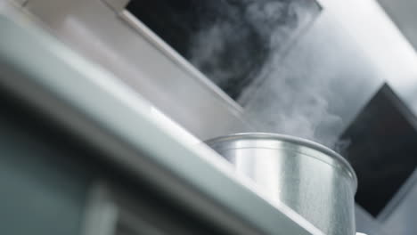 Low-angle-view-of-steam-getting-out-of-a-pan-at-a-kitchen-of-a-French-chef-restaurant