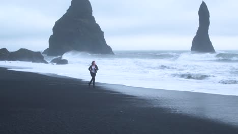 desperate woman running on deserted beach. aerial flying backwards