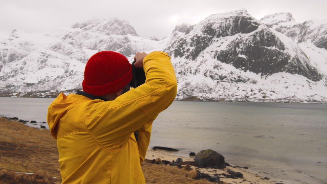 fotógrafo tomando fotos del paisaje invernal en lofoten noruega - toma panorámica