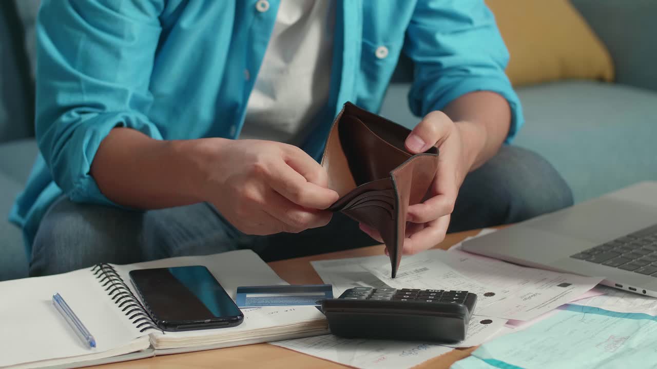 cerca de la mano del hombre sosteniendo y abriendo la billetera para comprobar el dinero