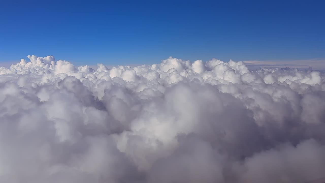 An immersive cockpit view through the pilot’s eyes while flying over an endless sea of cottony clouds bathed by the sunset light. 4K wide-angle shot