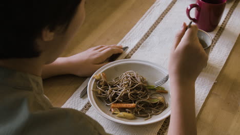 person enjoying a delicious plate of soba noodles