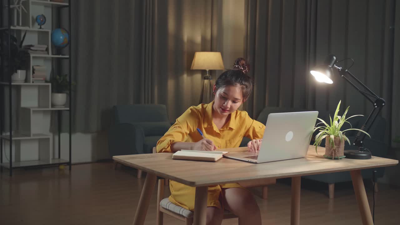 밤에 집에서 공부하는 젊은 여성