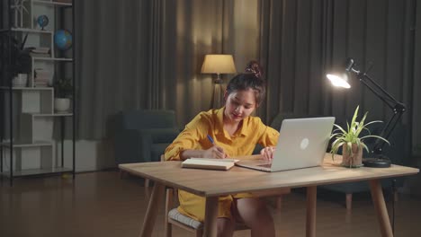 mujer joven estudiando en casa por la noche