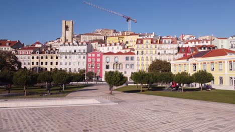 drone starting to rise over the facade of the casa dos bicos josé saramago foundation in alfama lisbon portugal europe in winter with blue skies and crane over houses