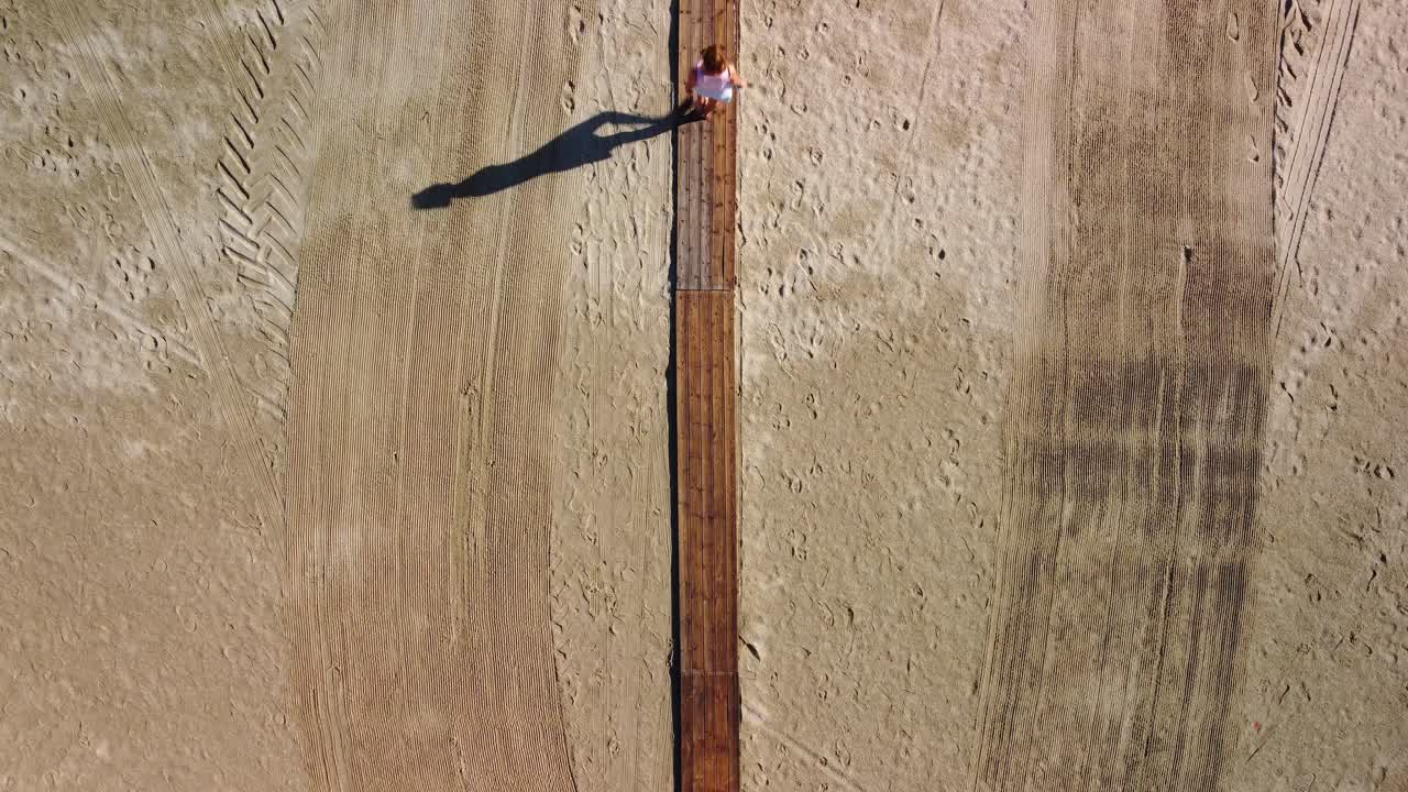 mujer caminando por un hermoso camino de madera a la playa en verano