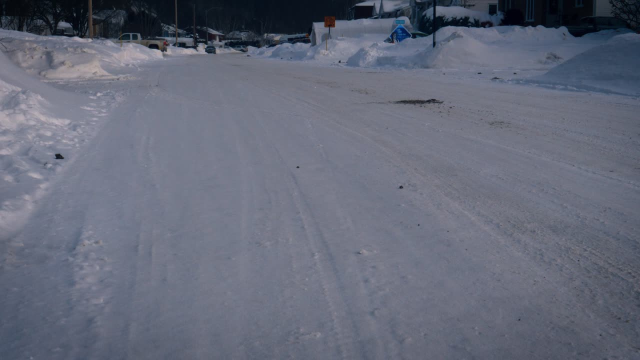 Footsteps of a person walking on the snow laden road leading towards the human settlement in Saguenay, Chicoutimi, Quebec, Canada.