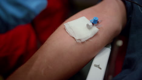 Paramedic-inserting-needle-cannula-in-arm.-Worker-placing-IV-catheter-into-vein