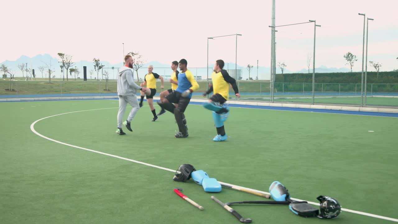 Celebrating victory, male hockey team huddling on field after match