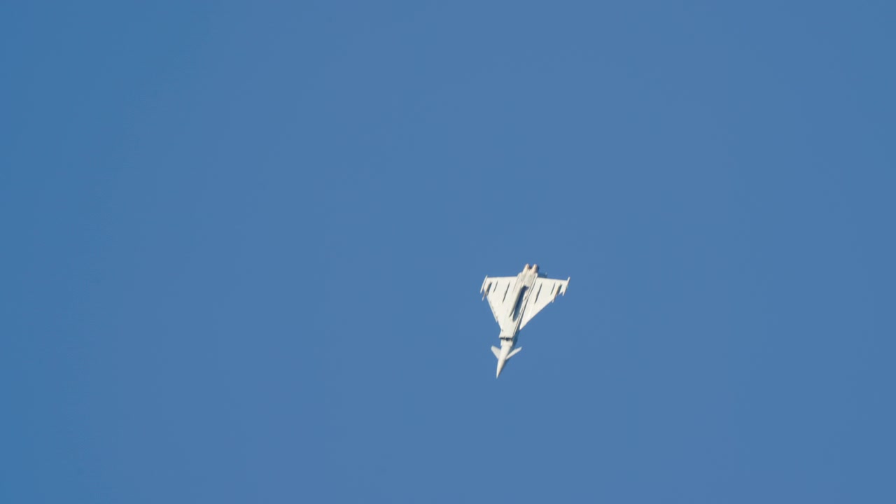 Militært jagerfly flyver på en klar blå himmel