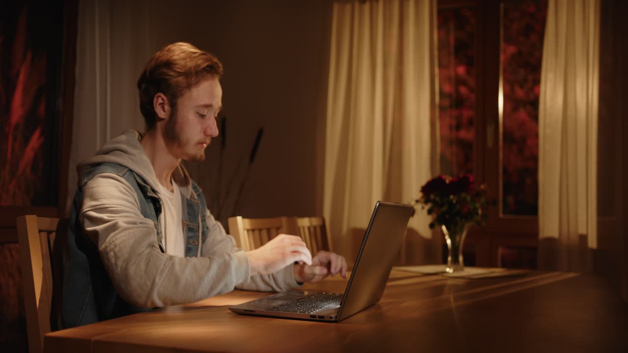 누군가가 아침에 거실에서 노트북에 타이핑을 하고 있습니다. 외부 조명이 켜져 있습니다.