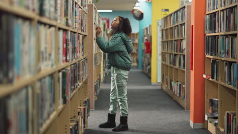 young girl browsing books in a library