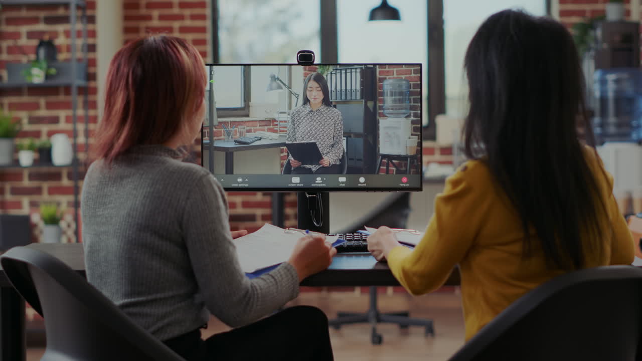 Asian women interviewing candidate to fill job vacancy on video call