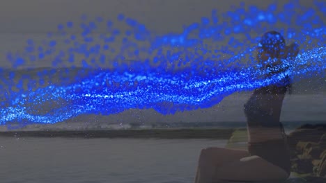 animación de manchas azules sobre mujer caucásica en la playa
