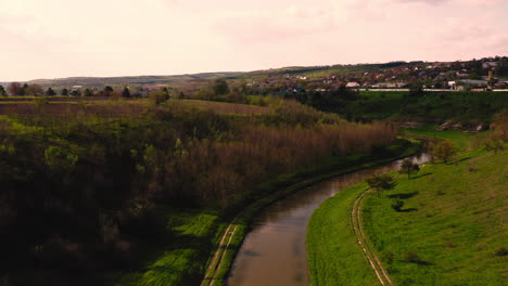 drone flying over curve of countryside water canal in moldova