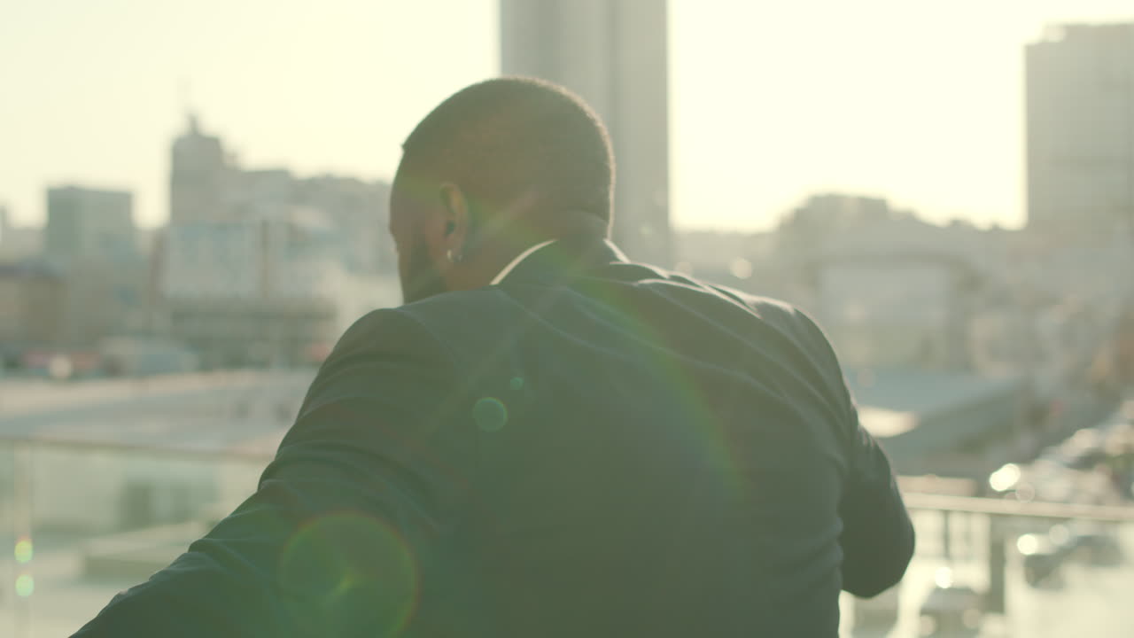 hombre de negocios africano sonriente bailando en la calle. trabajador masculino mirando a la cámara