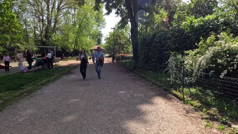 people walking in a lush garden path