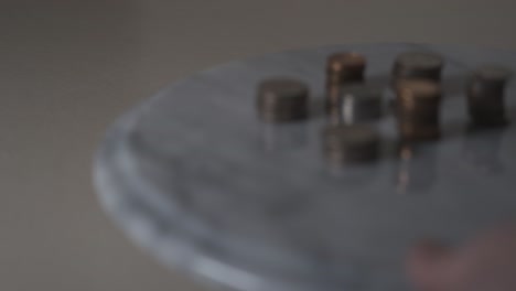 sliding into frame a table with coins stacked and sorted