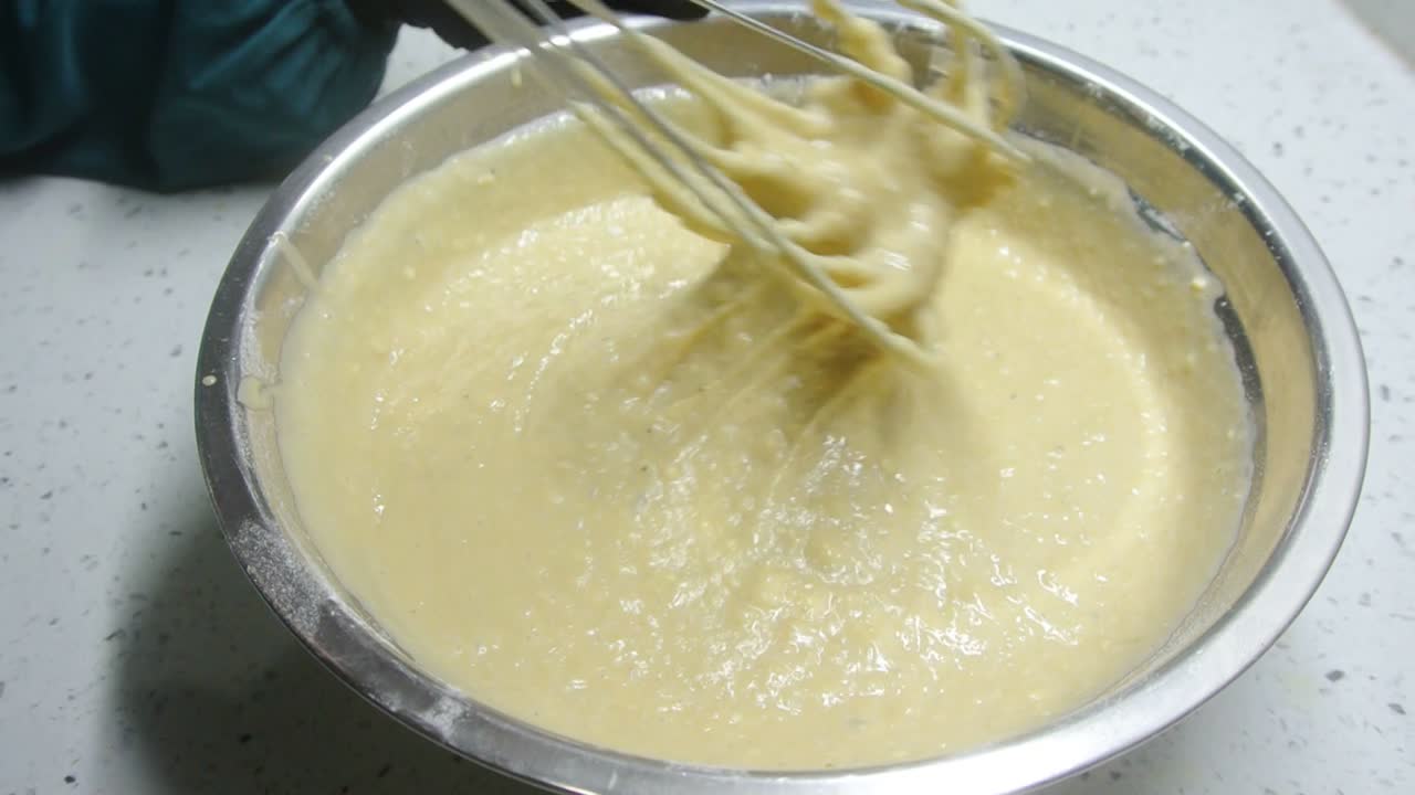 Mix the flour and other ingredients until well blended manually. It is the early stage of the baking bread and cakes process. This will take some time to get a good mix.