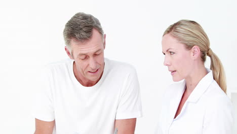 Doctor-showing-clipboard-to-her-patient-with-crutch