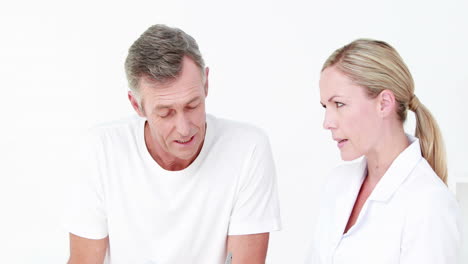 doctor showing clipboard to her patient with crutch