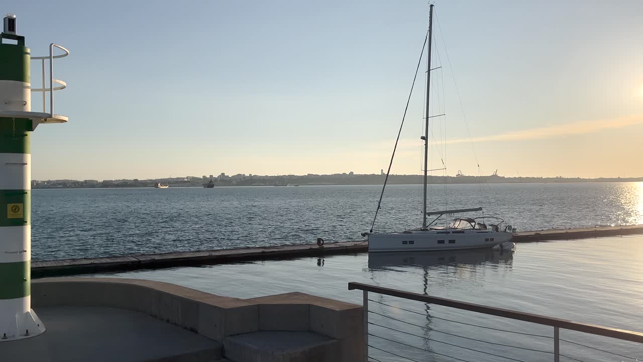 Yacht ormeggiato nel porto turistico di Setúbal, Portogallo, con vista sulla penisola di Troia.