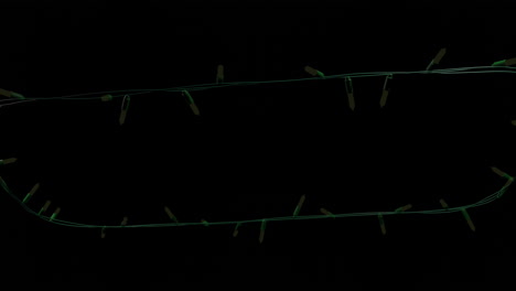 Yellow-christmas-string-lights-flashing-on-black-background