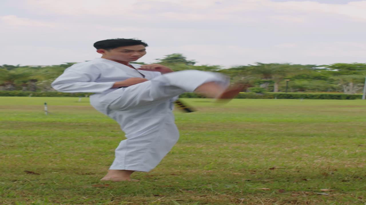 Vận động viên nam tập luyện ngoài trời trong lớp học Taekwondo