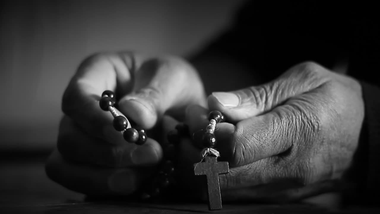 Vídeo de stock de manos rezando con cruz con personas