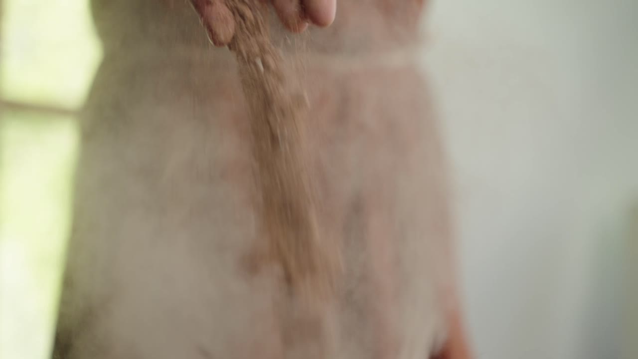 손에서 박격포로 떨어지는 붉은 모래 토양, 보기를 닫습니다