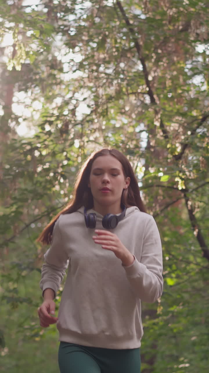 atleta mujer corriendo en el bosque. ejercicio cardio para mejorar la resistencia y el cuerpo tonificado. entrenamiento de fitness profesional en la naturaleza en un día soleado de verano