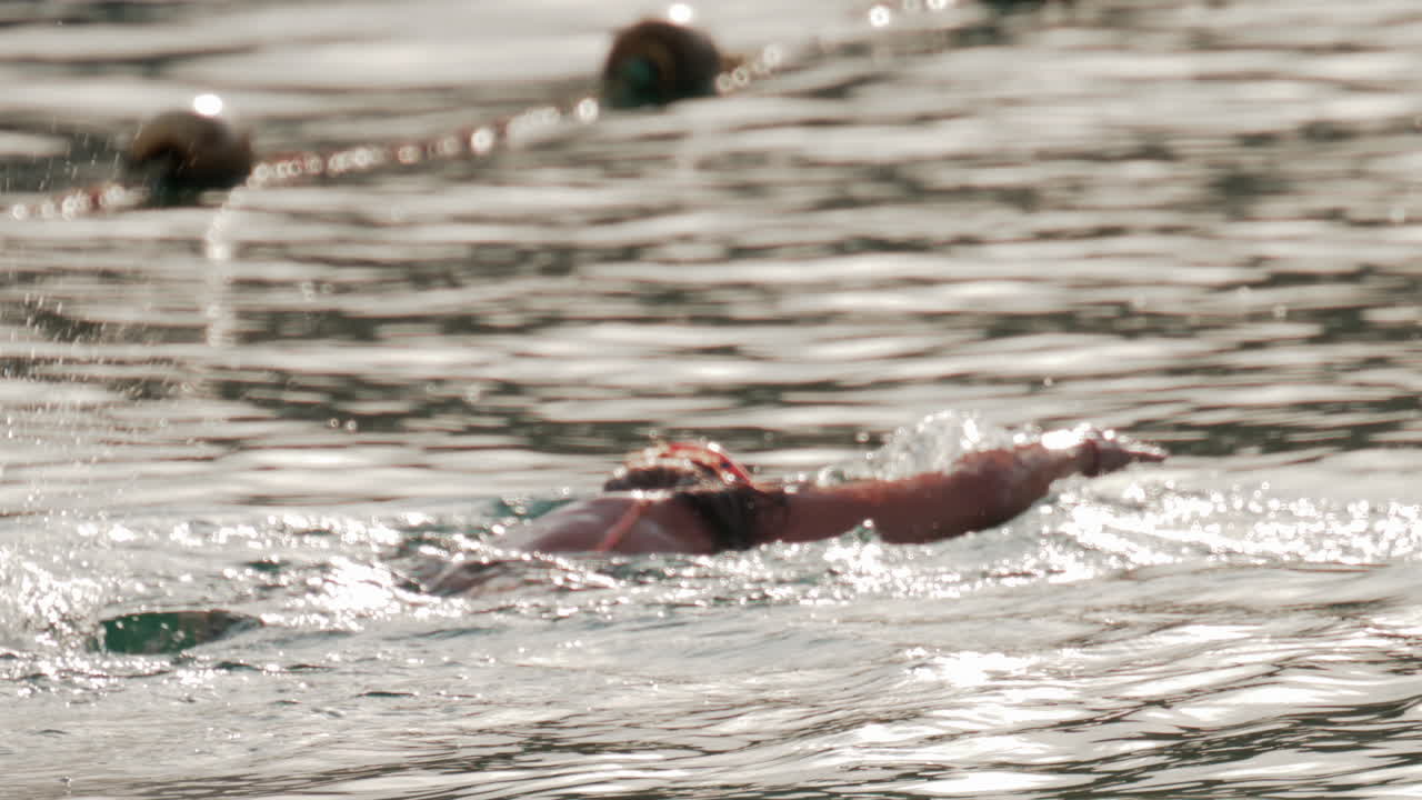 Cannes, France - October 9, 2025: A woman prepares for snorkeling in the ocean, adjusting her mask while floating in gentle water under soft sunlight
