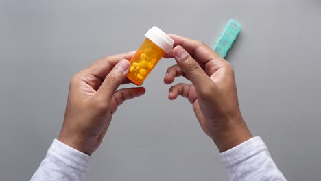 person holding a pill bottle and pill organizer