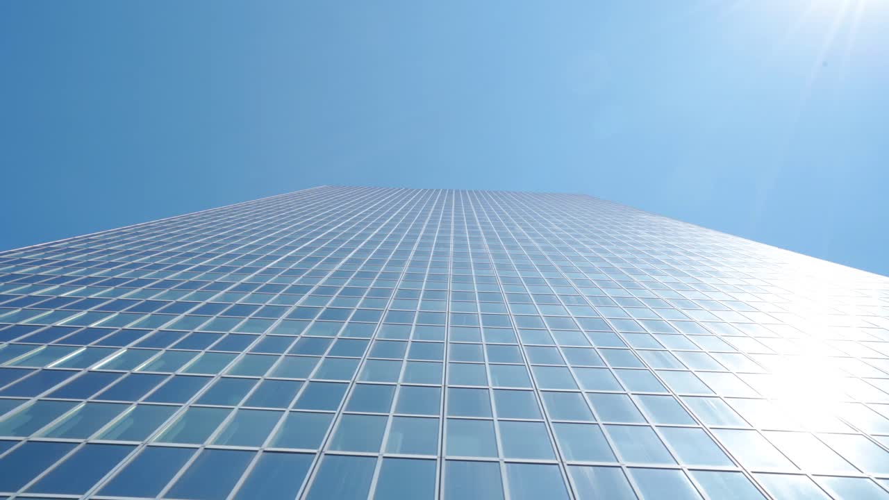 벨기에 브뤼셀에 있는 마천루 유리 사무실 건물에서 상향 각도로 옆으로 돌리가 날아다니는 새와 함께