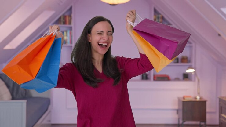 mujer india feliz bailando con bolsas de compras